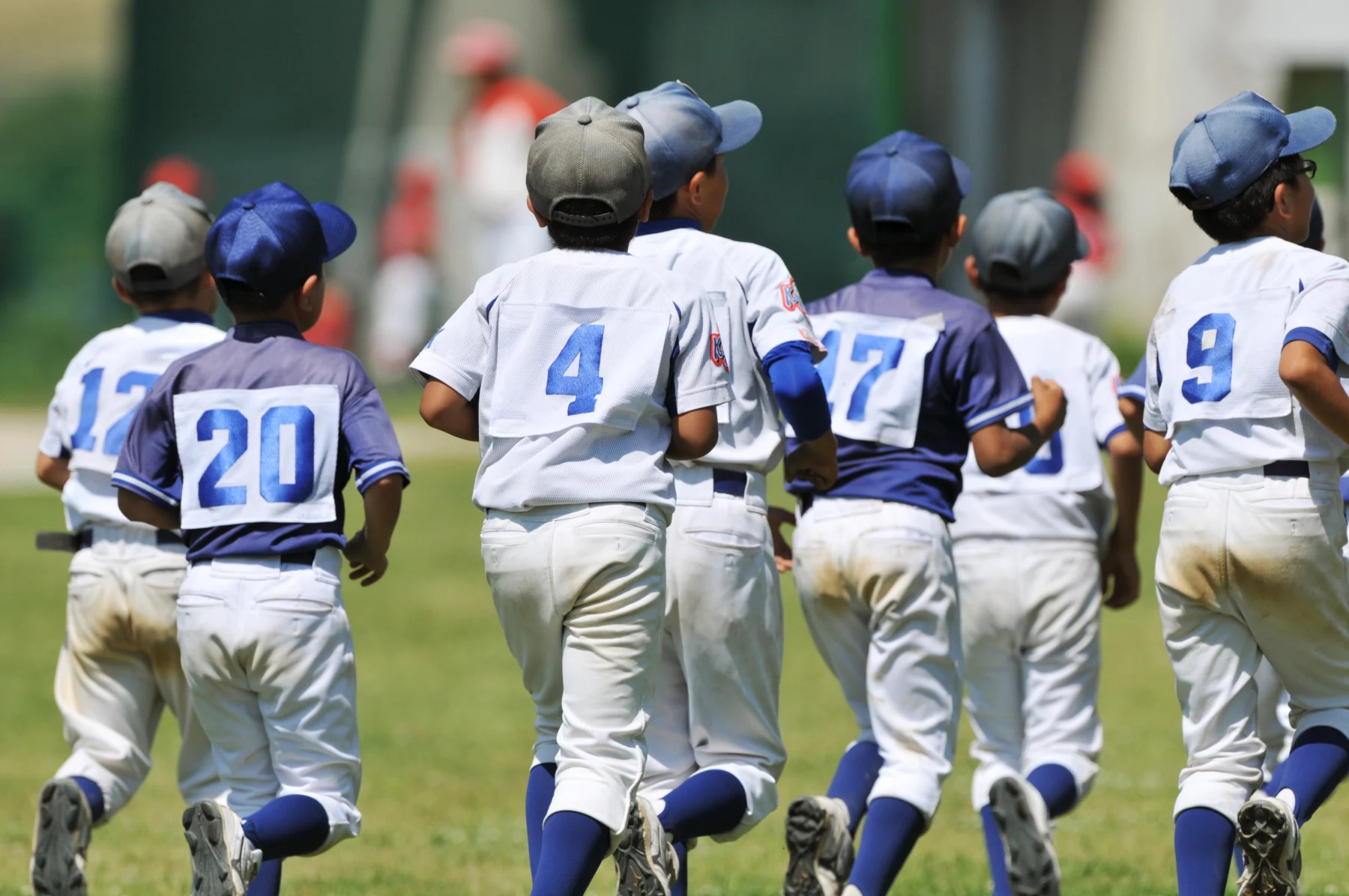 自分の手足に合った道具を身につけて元気に練習する少年野球のイメージ